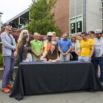 Mayor Wilson signing executive order surrounded by community leaders